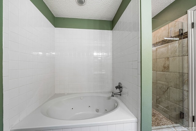 bathroom with plus walk in shower and a textured ceiling