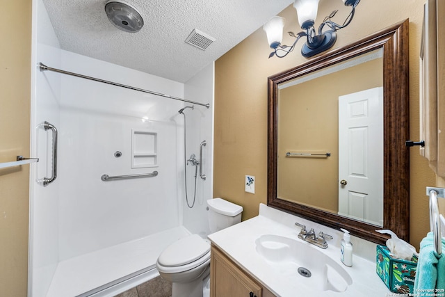 bathroom featuring vanity, toilet, a textured ceiling, and walk in shower