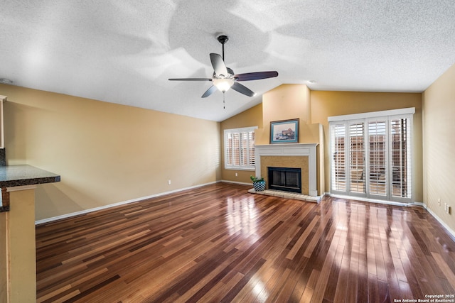 unfurnished living room with hardwood / wood-style flooring, plenty of natural light, and lofted ceiling