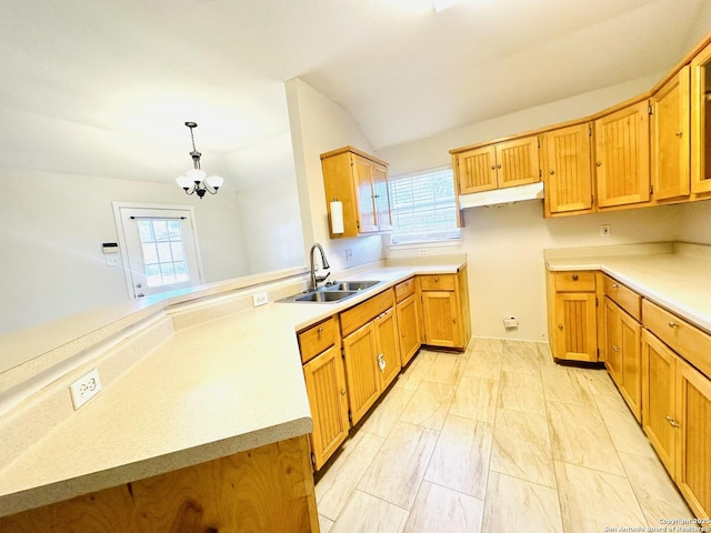 kitchen featuring vaulted ceiling, pendant lighting, sink, a notable chandelier, and kitchen peninsula