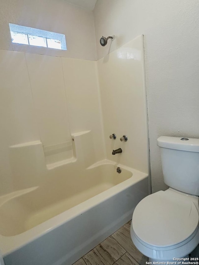 bathroom featuring shower / bathing tub combination and toilet