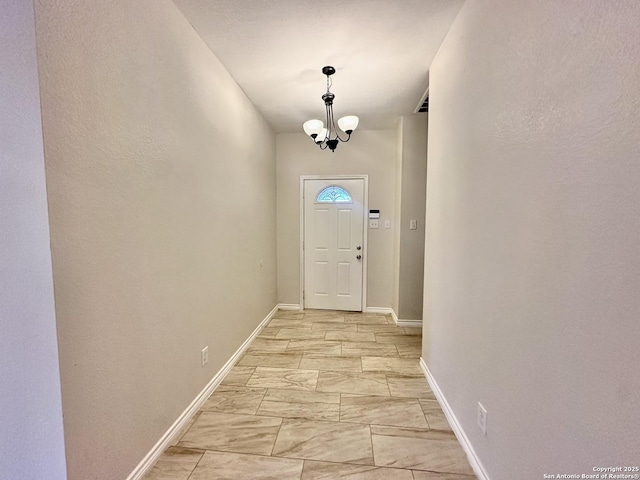 doorway to outside with an inviting chandelier