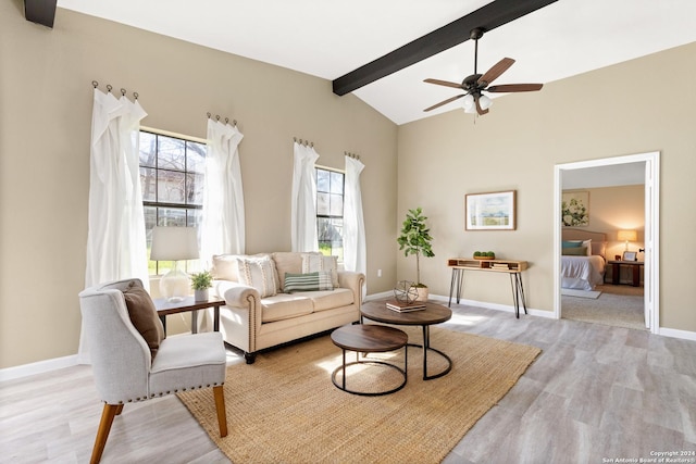 living room with ceiling fan, lofted ceiling with beams, and light wood-type flooring