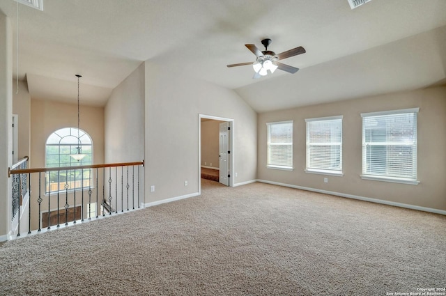 spare room with ceiling fan, light colored carpet, and vaulted ceiling