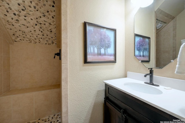 bathroom with vanity and tiled shower