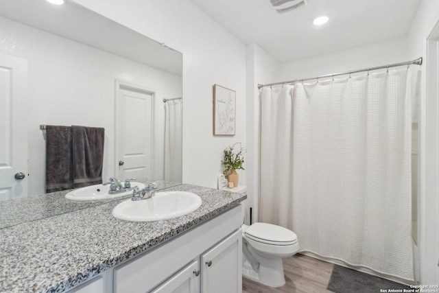 bathroom with vanity, hardwood / wood-style floors, and toilet