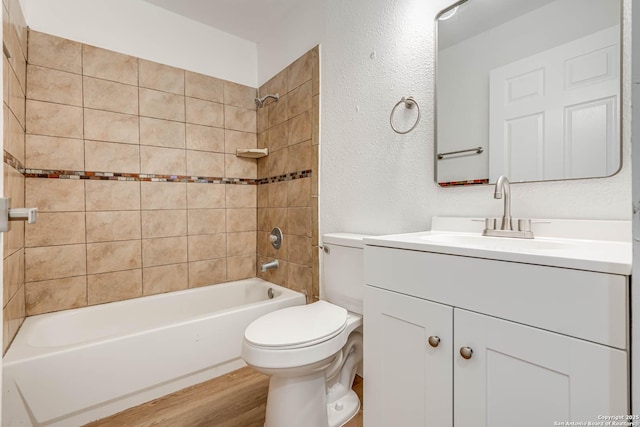 full bathroom featuring vanity, toilet, tiled shower / bath combo, and hardwood / wood-style floors