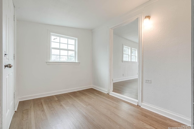 spare room featuring plenty of natural light and light hardwood / wood-style floors