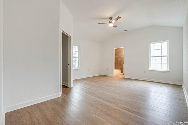 spare room featuring ceiling fan, vaulted ceiling, a healthy amount of sunlight, and light hardwood / wood-style floors