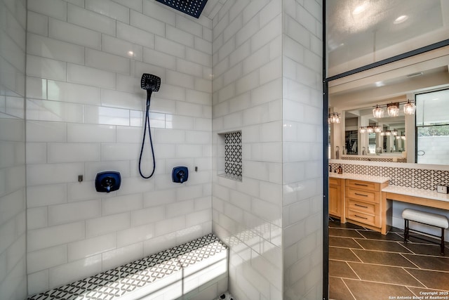 bathroom with tile patterned flooring, vanity, tiled shower, and decorative backsplash