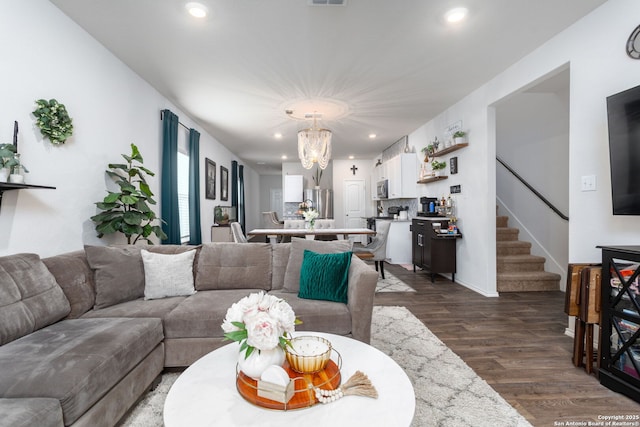 living room with dark wood-type flooring and a chandelier