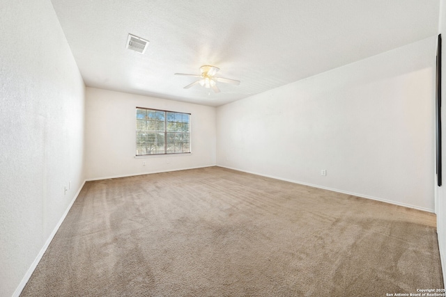 carpeted spare room featuring ceiling fan and a textured ceiling