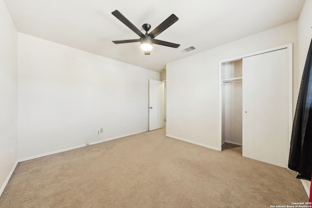 unfurnished bedroom with light carpet, ceiling fan, and a closet