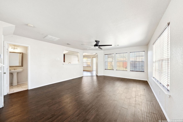 unfurnished living room with ceiling fan, sink, light hardwood / wood-style floors, and a textured ceiling
