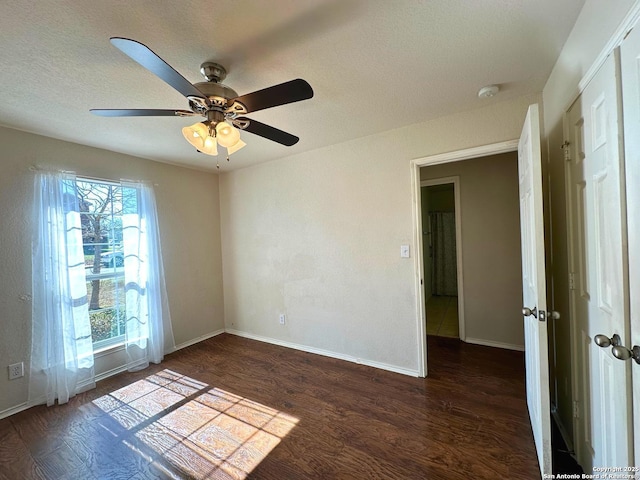 unfurnished room featuring ceiling fan, dark hardwood / wood-style floors, and a textured ceiling