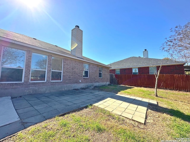 rear view of house featuring a patio area and a lawn