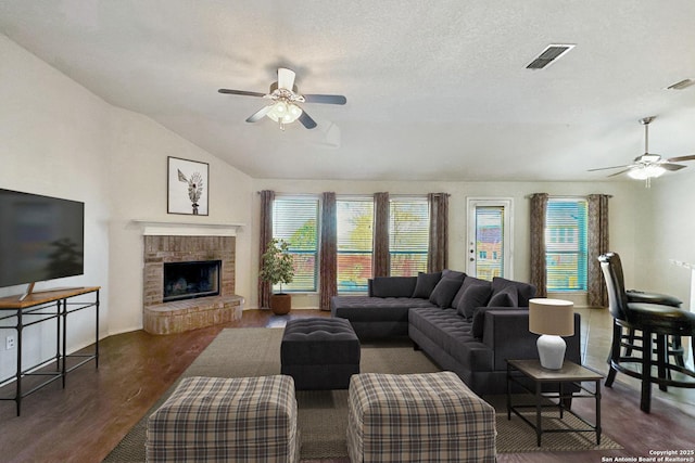 living room featuring vaulted ceiling, a textured ceiling, ceiling fan, and dark hardwood / wood-style flooring