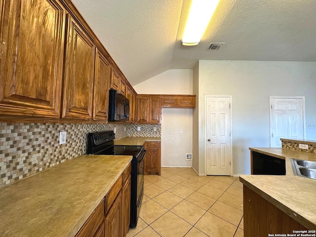 kitchen with vaulted ceiling, decorative backsplash, light tile patterned floors, black appliances, and a textured ceiling