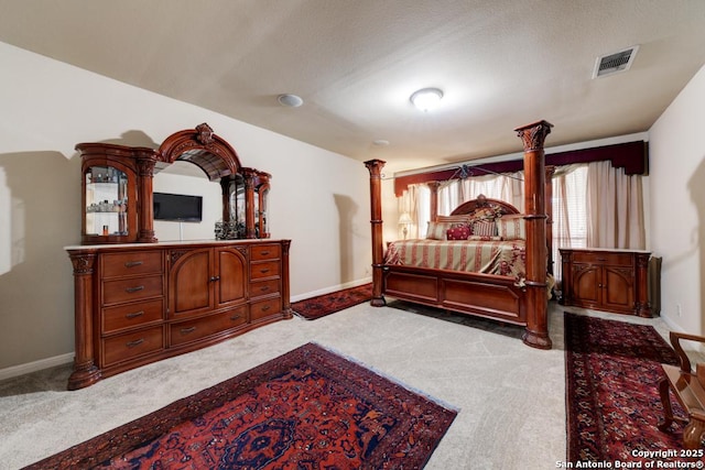 bedroom with light colored carpet and decorative columns