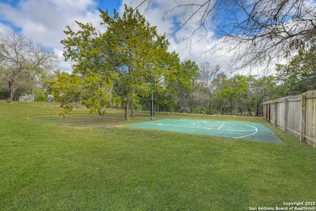 view of basketball court with a lawn