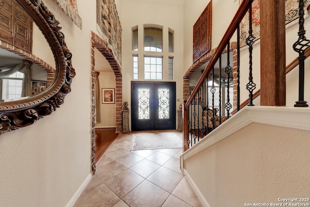 tiled foyer entrance featuring french doors and a high ceiling