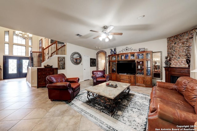 tiled living room featuring ceiling fan with notable chandelier