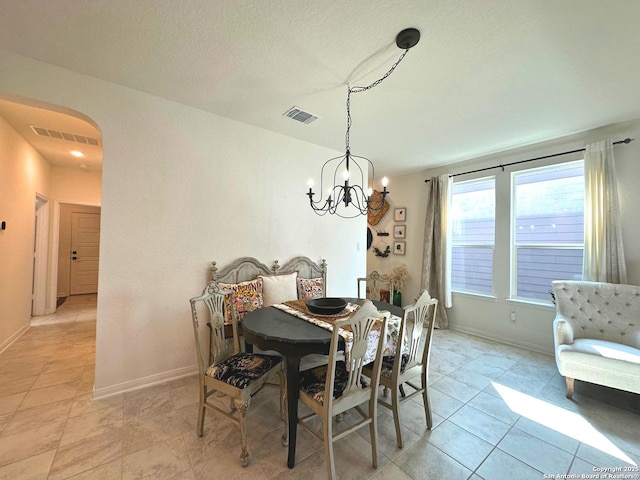 dining space with a chandelier and light tile patterned floors