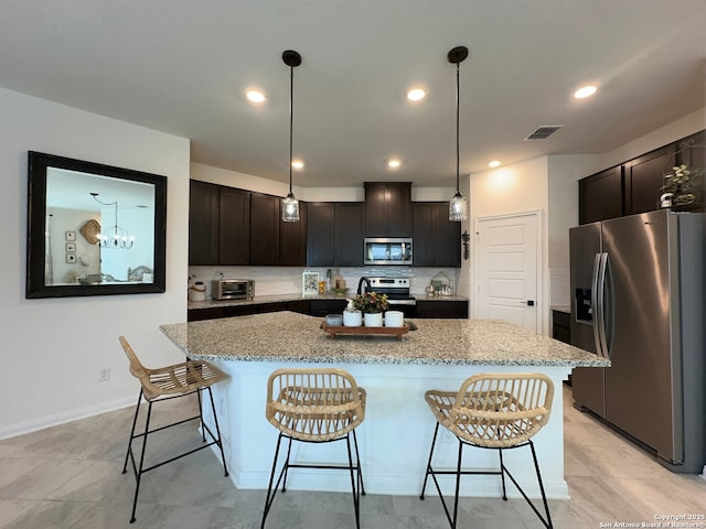 kitchen with hanging light fixtures, a center island, appliances with stainless steel finishes, and dark brown cabinets