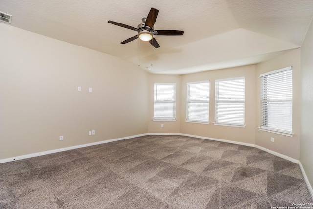 spare room with ceiling fan, lofted ceiling, carpet, and a textured ceiling