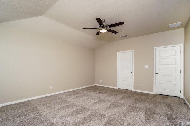 unfurnished bedroom featuring lofted ceiling, carpet, and a textured ceiling