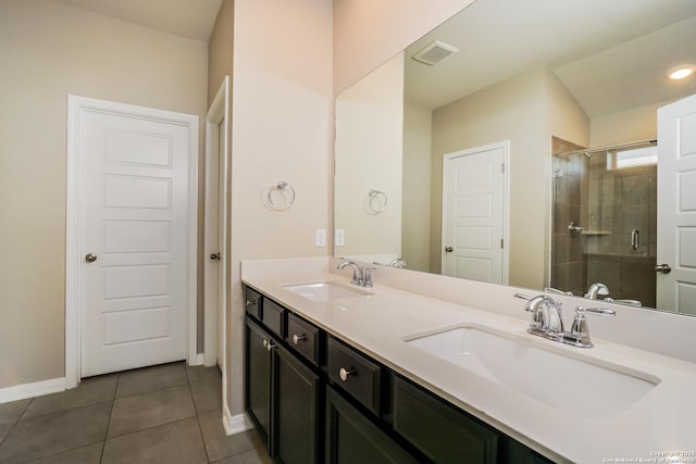 bathroom featuring vanity, a shower with shower door, and tile patterned flooring