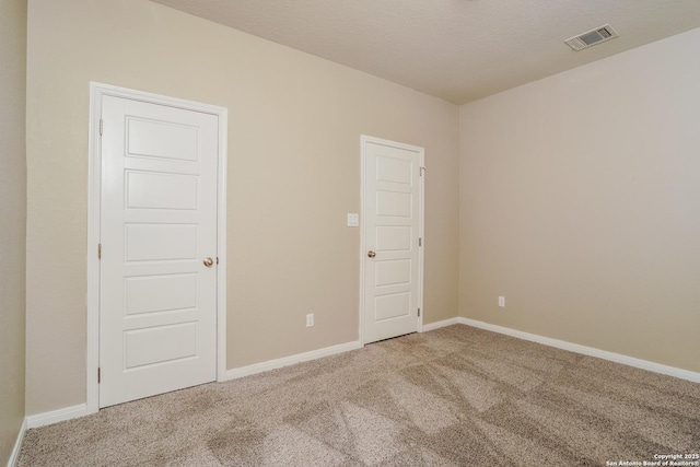 carpeted spare room featuring a textured ceiling