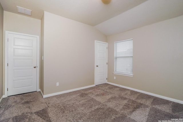 carpeted spare room with lofted ceiling