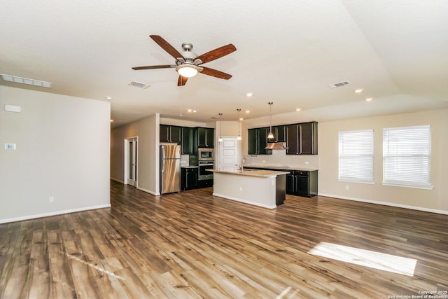 unfurnished living room featuring dark wood-type flooring, ceiling fan, and sink