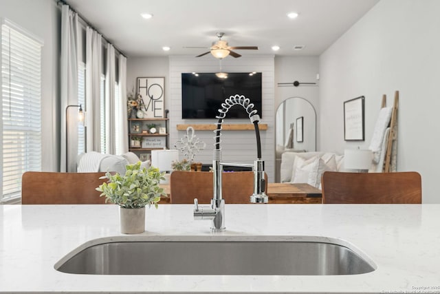 kitchen featuring light stone counters and sink