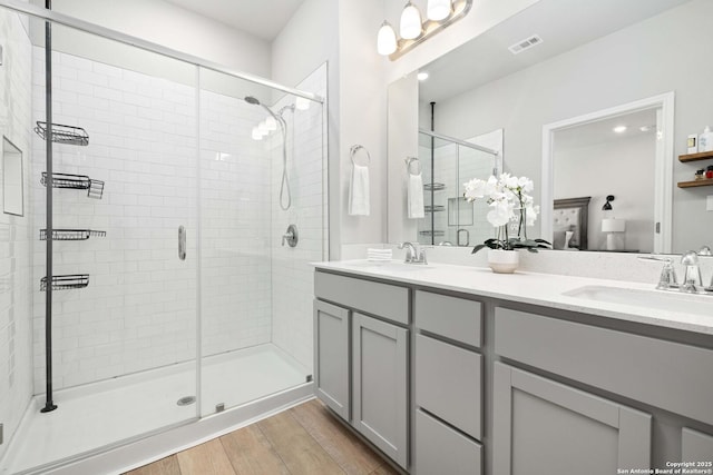 bathroom featuring a shower with door, vanity, and hardwood / wood-style floors