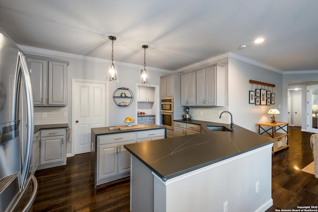 kitchen with gray cabinetry, sink, a kitchen island, and appliances with stainless steel finishes