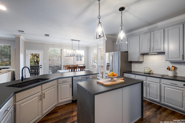 kitchen with stainless steel appliances, sink, a kitchen island, and gray cabinetry