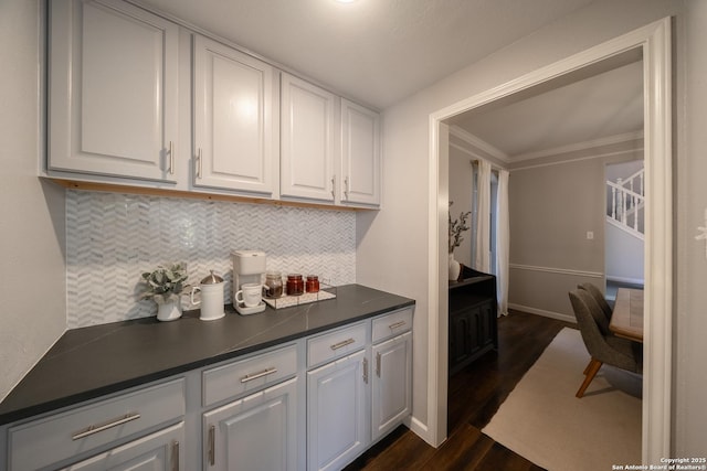 kitchen with dark hardwood / wood-style flooring, tasteful backsplash, ornamental molding, and white cabinets