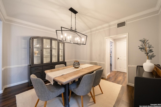 dining room with dark wood-type flooring and crown molding