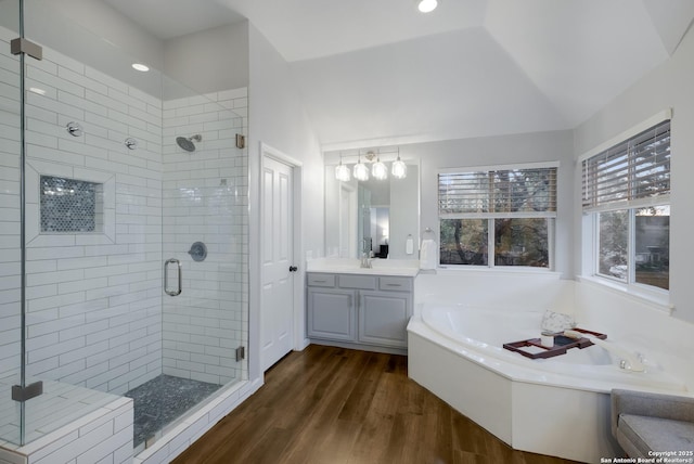 bathroom with hardwood / wood-style flooring, vanity, plus walk in shower, and vaulted ceiling