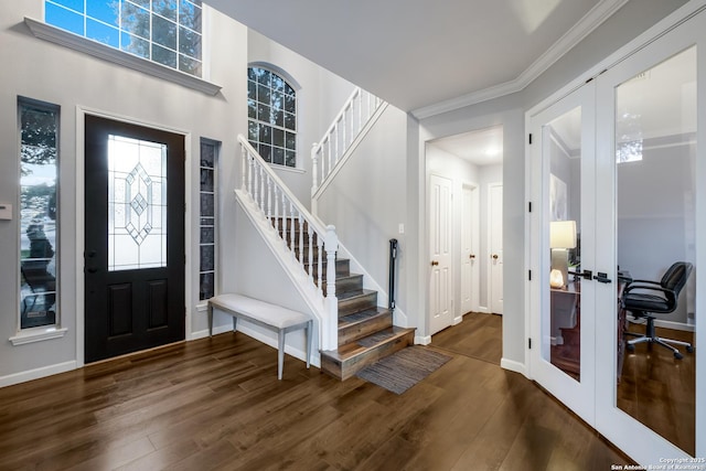 entryway with french doors, a towering ceiling, ornamental molding, and dark hardwood / wood-style floors