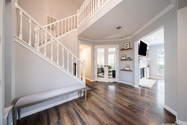 entrance foyer with dark wood-type flooring, ornamental molding, and french doors