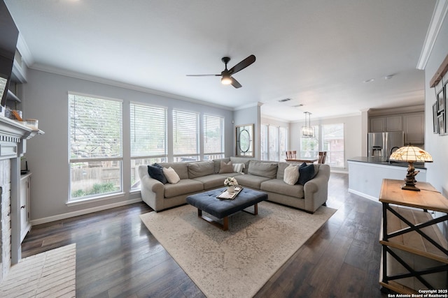 living room featuring ornamental molding, a brick fireplace, dark wood-type flooring, and a healthy amount of sunlight