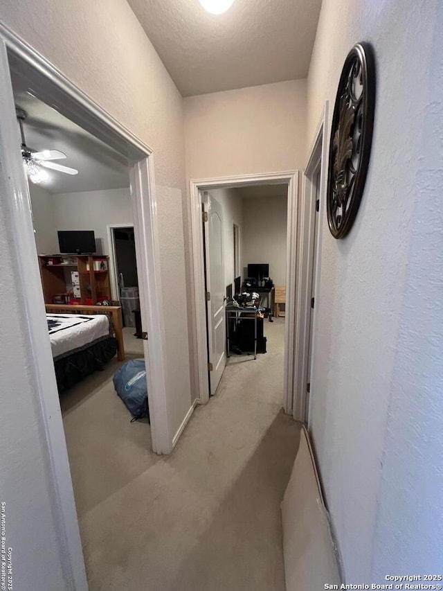 hallway featuring light colored carpet