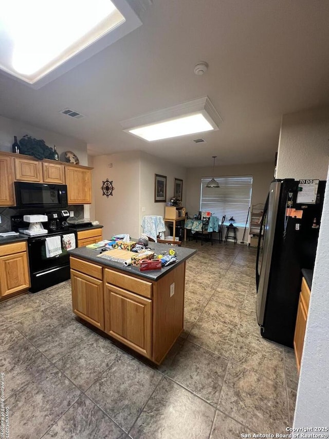 kitchen featuring pendant lighting, black appliances, and a center island