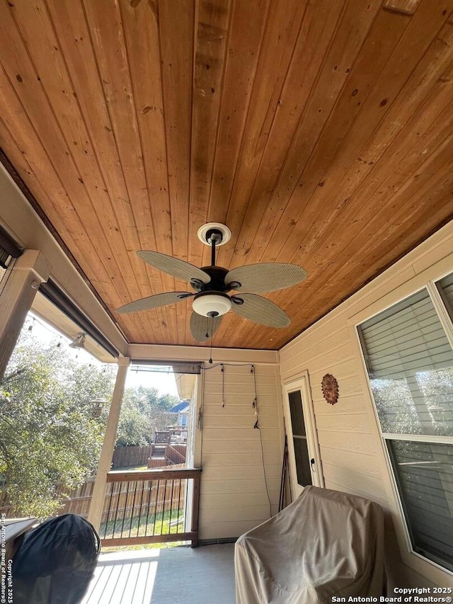 sunroom with ceiling fan and wooden ceiling