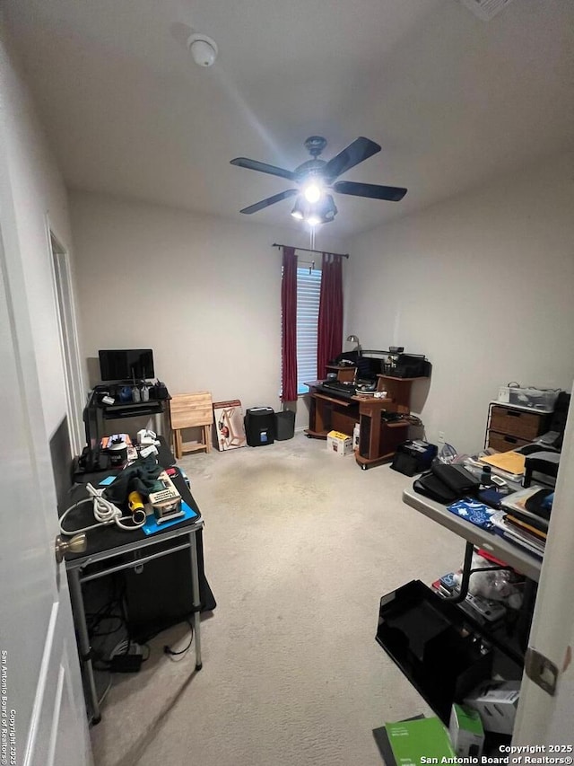 carpeted home office featuring ceiling fan