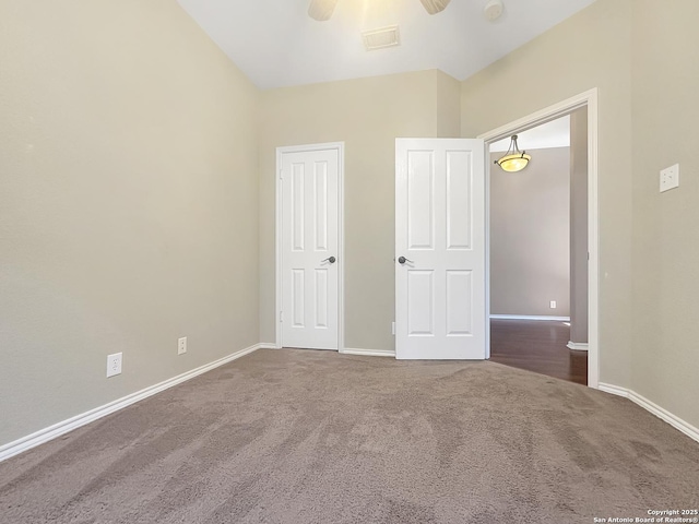 unfurnished bedroom with ceiling fan and dark carpet