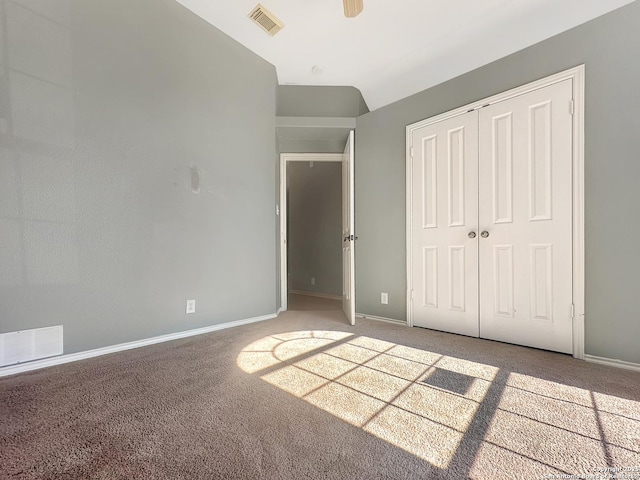 unfurnished bedroom featuring carpet floors, a closet, and vaulted ceiling